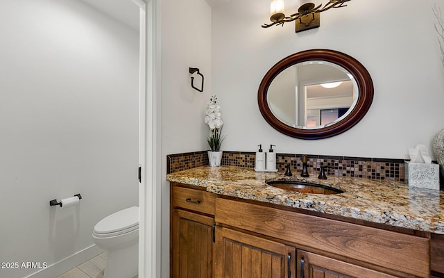 bathroom with vanity, backsplash, and toilet