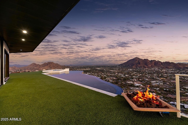 yard at dusk with a mountain view and a fire pit