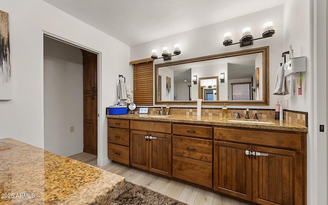 bathroom with vanity, hardwood / wood-style floors, and backsplash