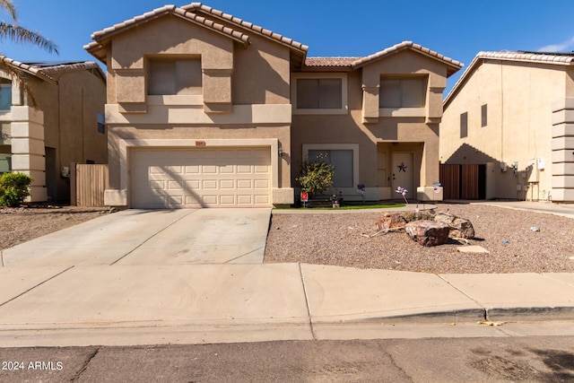 view of front facade featuring an attached garage, a tile roof, concrete driveway, and stucco siding