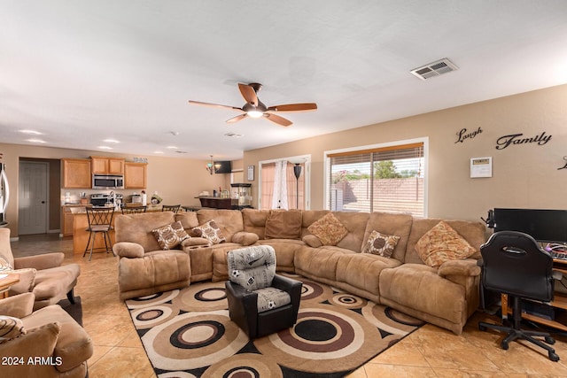 living area featuring light tile patterned floors, ceiling fan, and visible vents