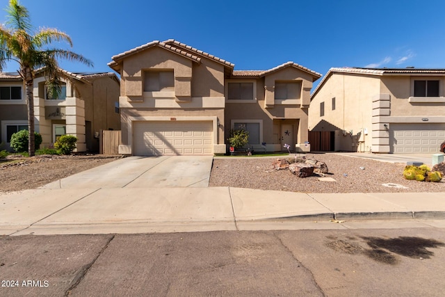 view of front of property with a garage, a tiled roof, concrete driveway, and stucco siding