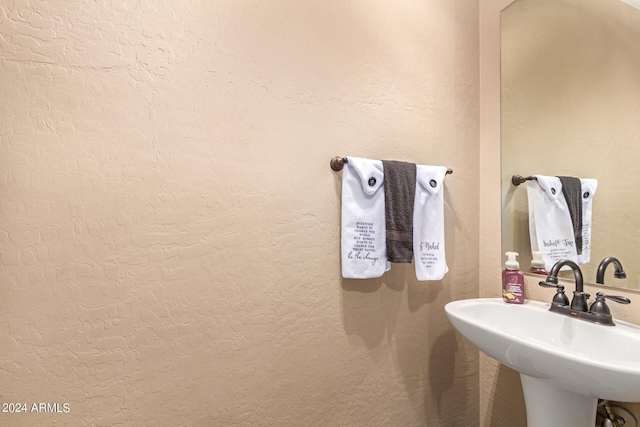 bathroom featuring a textured wall and a sink