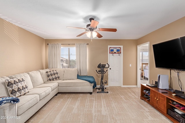 living area with light carpet, ceiling fan, and baseboards