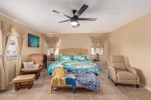 bedroom with a ceiling fan, multiple windows, visible vents, and carpet flooring