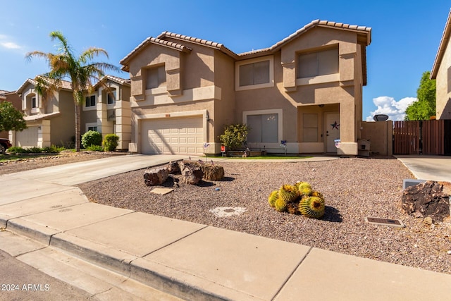 view of front of property featuring a tiled roof, a gate, concrete driveway, and stucco siding