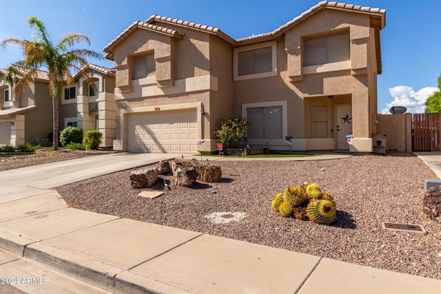 view of front of house featuring stucco siding, concrete driveway, an attached garage, a gate, and a tiled roof