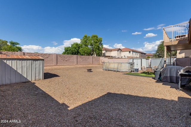 view of yard featuring an outbuilding, a storage unit, and a fenced backyard