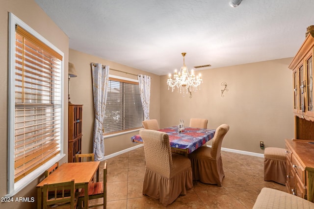 dining space with an inviting chandelier, baseboards, and light tile patterned flooring