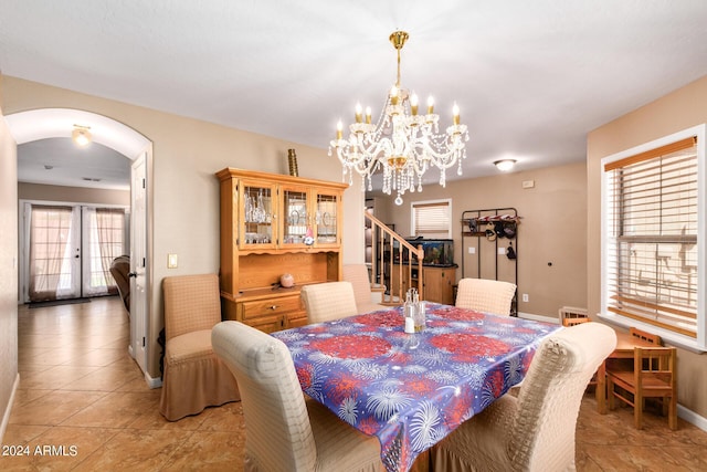 dining area with arched walkways, french doors, light tile patterned floors, baseboards, and stairs