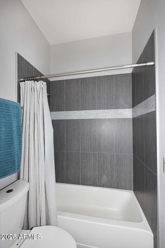 bathroom with shower / bathtub combination with curtain and toilet