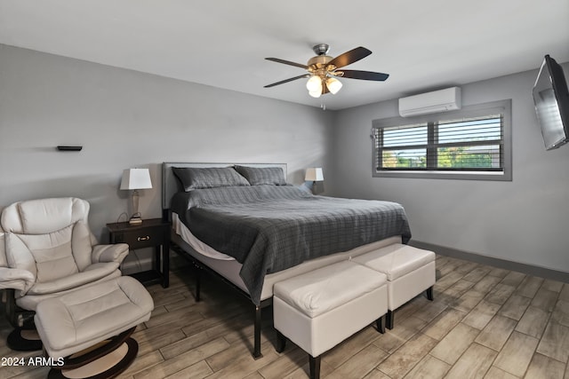 bedroom featuring ceiling fan, light wood-type flooring, and a wall mounted air conditioner