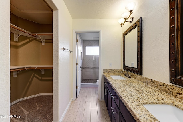 bathroom with walk in shower, vanity, a textured ceiling, hardwood / wood-style floors, and toilet