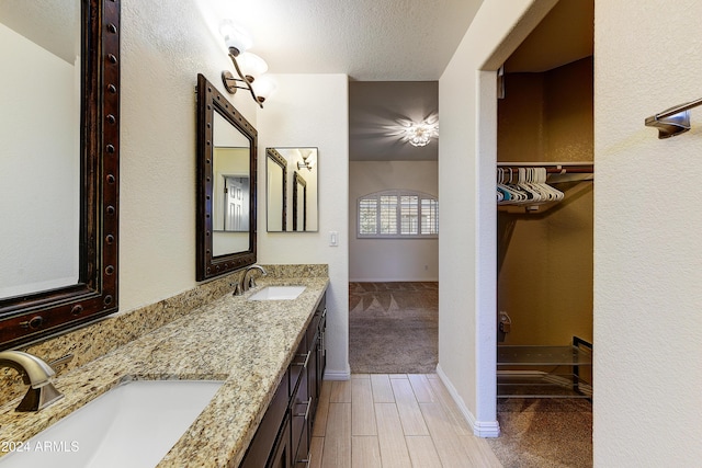 bathroom with hardwood / wood-style floors, vanity, and a textured ceiling