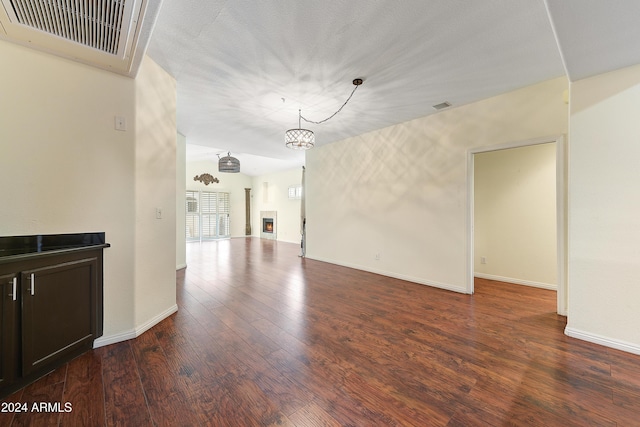 unfurnished living room with wood-type flooring and a notable chandelier