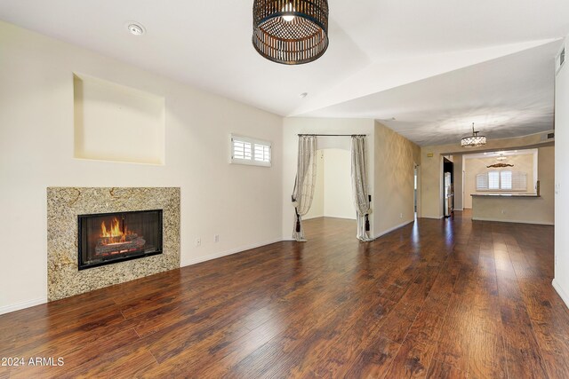8653 E Royal Palm Rd Unit 2005, Scottsdale, AZ 85258 - unfurnished living room featuring a high end fireplace, hardwood / wood-style flooring, a chandelier, and vaulted ceiling