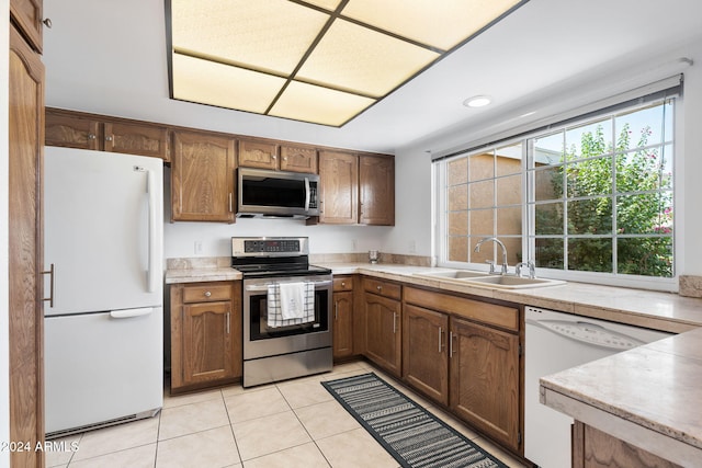 kitchen with light tile patterned floors, appliances with stainless steel finishes, and sink