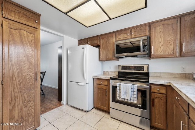 kitchen featuring stainless steel appliances and light tile patterned flooring