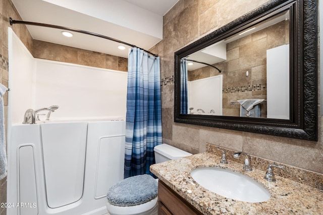 full bathroom featuring shower / tub combo with curtain, tile walls, vanity, and toilet