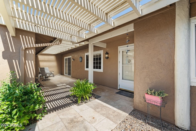 property entrance featuring a patio area and a pergola