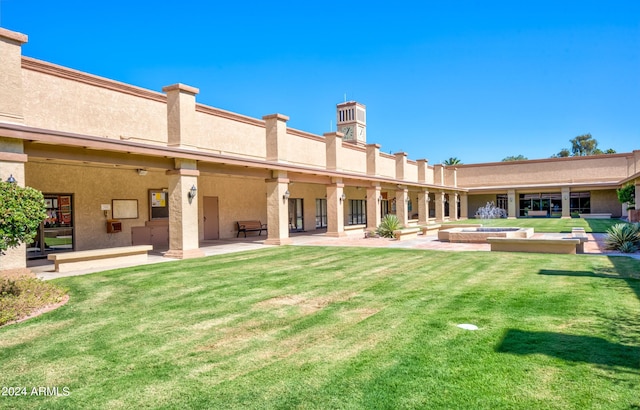 back of property featuring a patio and a lawn