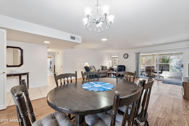 dining space with a notable chandelier and light hardwood / wood-style floors