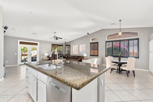 kitchen with open floor plan, light tile patterned flooring, vaulted ceiling, a sink, and dishwasher