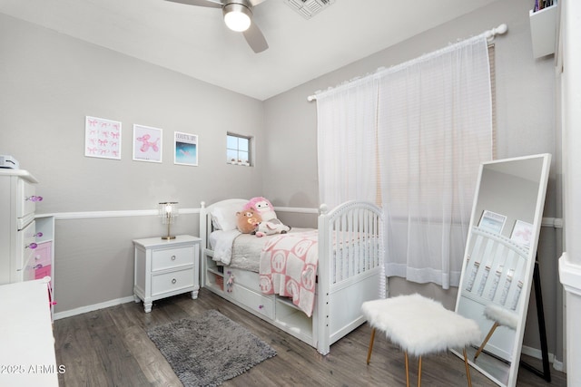 bedroom with a ceiling fan, visible vents, baseboards, and wood finished floors