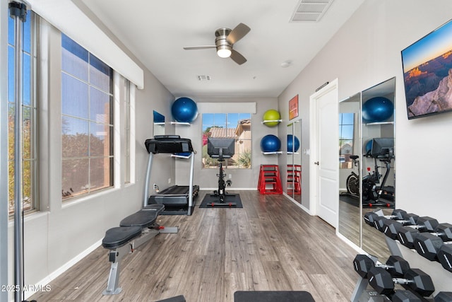 exercise area featuring a ceiling fan, wood finished floors, visible vents, and baseboards