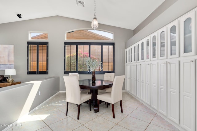 dining area featuring lofted ceiling, light tile patterned floors, baseboards, and visible vents