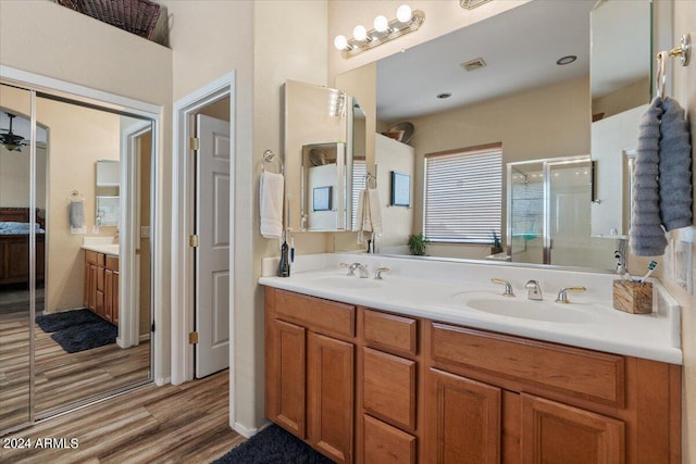 bathroom with vanity, a shower with shower door, and hardwood / wood-style floors