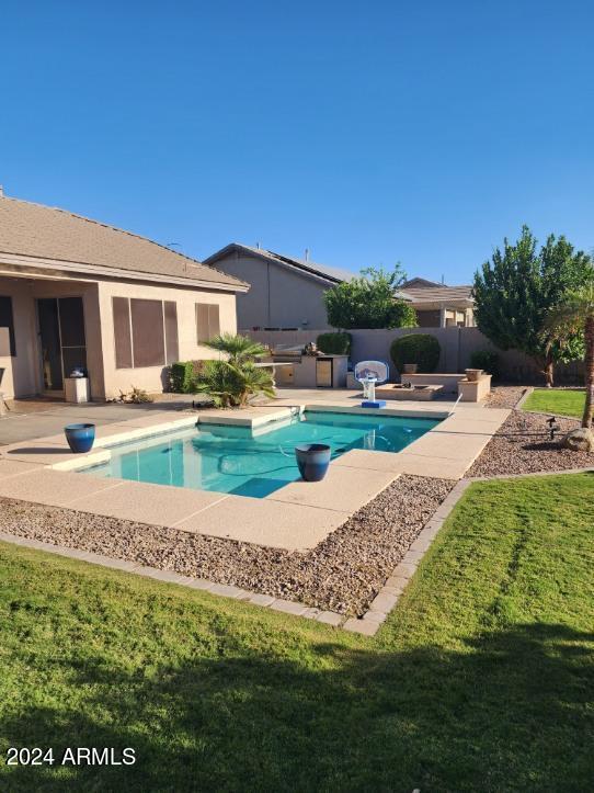 view of swimming pool featuring a lawn and a patio