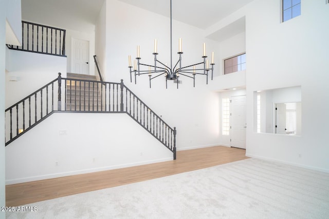 6014 W Oberlin Way, Phoenix, AZ 85083 - stairway featuring a chandelier, carpet flooring, a towering ceiling, and wood finished floors