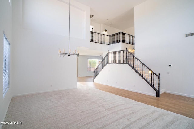 6014 W Oberlin Way, Phoenix, AZ 85083 - unfurnished living room with stairway, wood finished floors, a high ceiling, carpet, and a chandelier