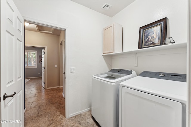 laundry area with independent washer and dryer and cabinets