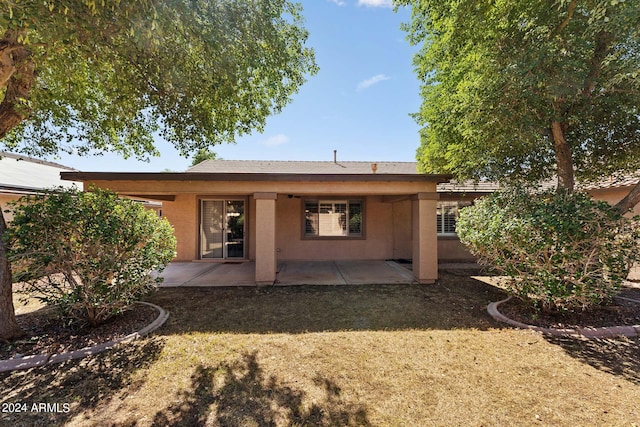 rear view of house with a patio and a yard