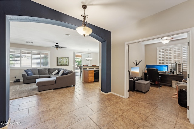 living room with ceiling fan with notable chandelier