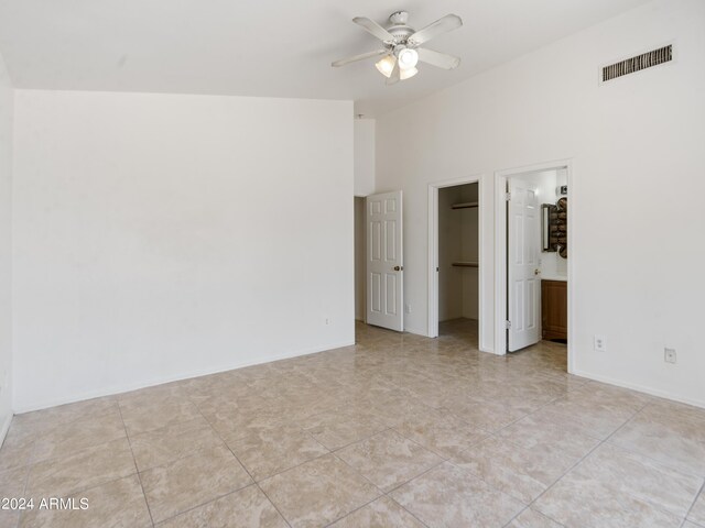 unfurnished bedroom featuring ensuite bathroom, lofted ceiling, a spacious closet, and a closet