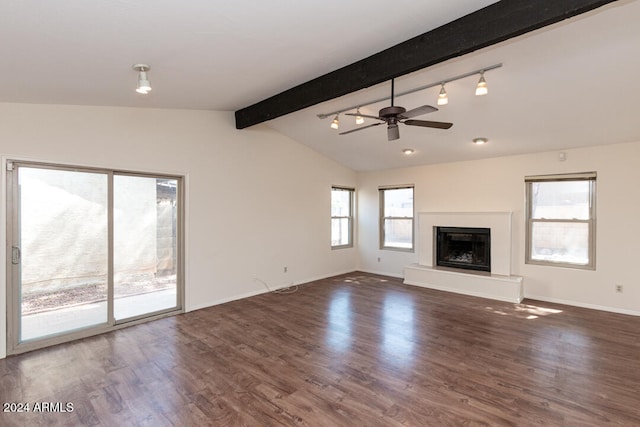 unfurnished living room featuring lofted ceiling with beams, a healthy amount of sunlight, and dark hardwood / wood-style floors