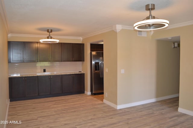 kitchen featuring light wood finished floors, stainless steel fridge with ice dispenser, light countertops, backsplash, and baseboards