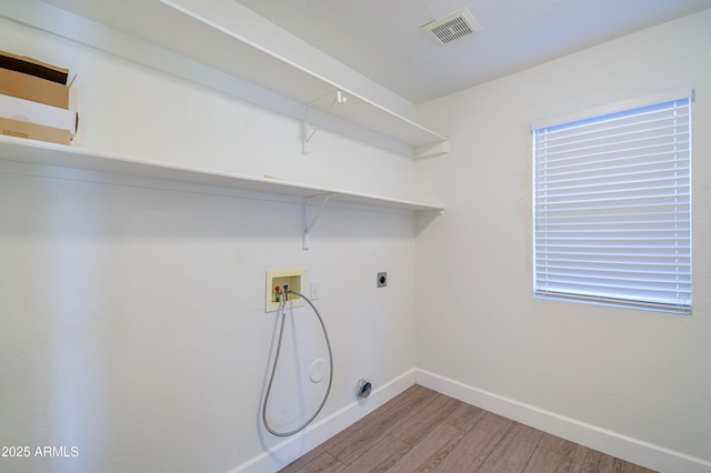 laundry area featuring laundry area, baseboards, visible vents, wood finished floors, and washer hookup