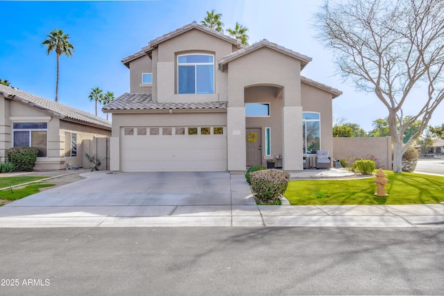 mediterranean / spanish-style house with a tile roof, stucco siding, concrete driveway, fence, and a garage