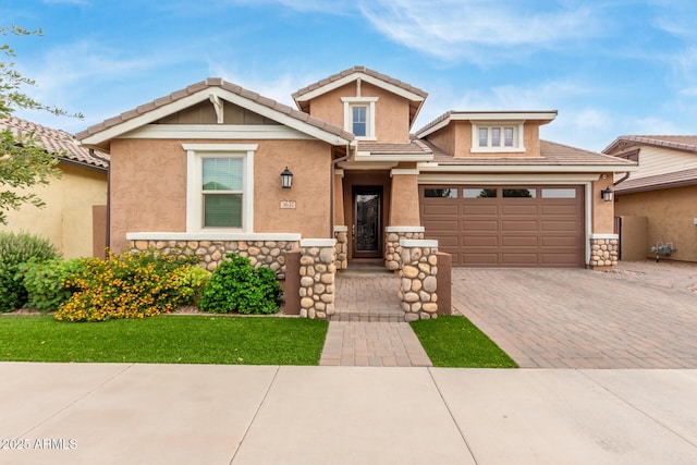 view of front of property with decorative driveway, stone siding, and stucco siding