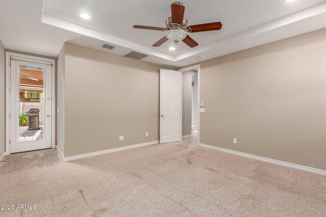 spare room featuring carpet floors, ceiling fan, baseboards, a tray ceiling, and recessed lighting