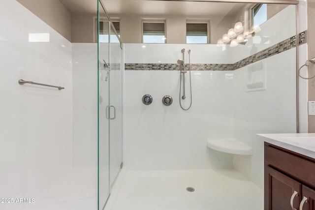 bathroom with a shower stall and vanity