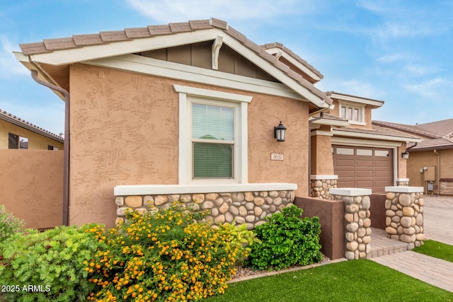 view of front of property featuring stucco siding, driveway, and fence