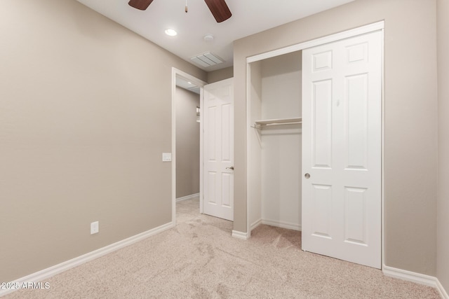 unfurnished bedroom with carpet flooring, baseboards, a closet, and a ceiling fan
