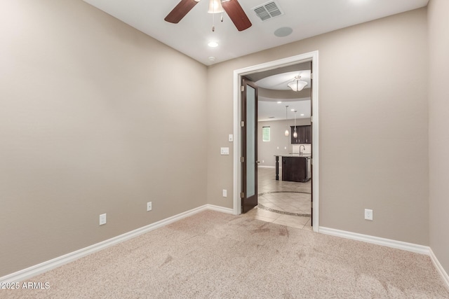 empty room with ceiling fan, carpet, baseboards, tile patterned floors, and recessed lighting