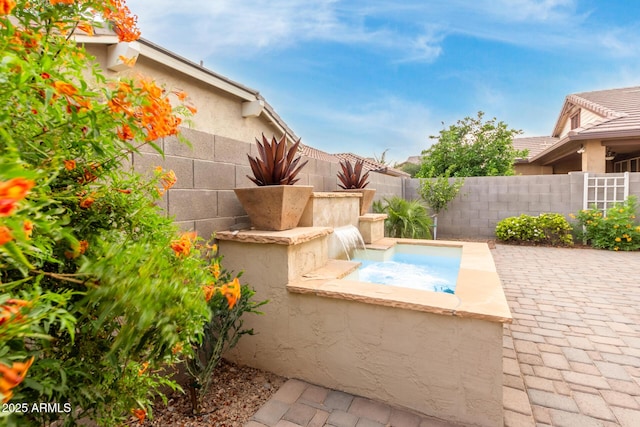 view of swimming pool with fence, an in-ground hot tub, and a patio