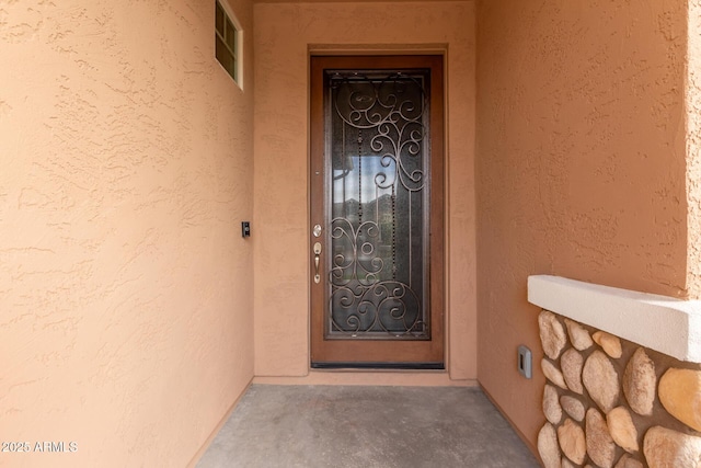 doorway to property featuring stucco siding